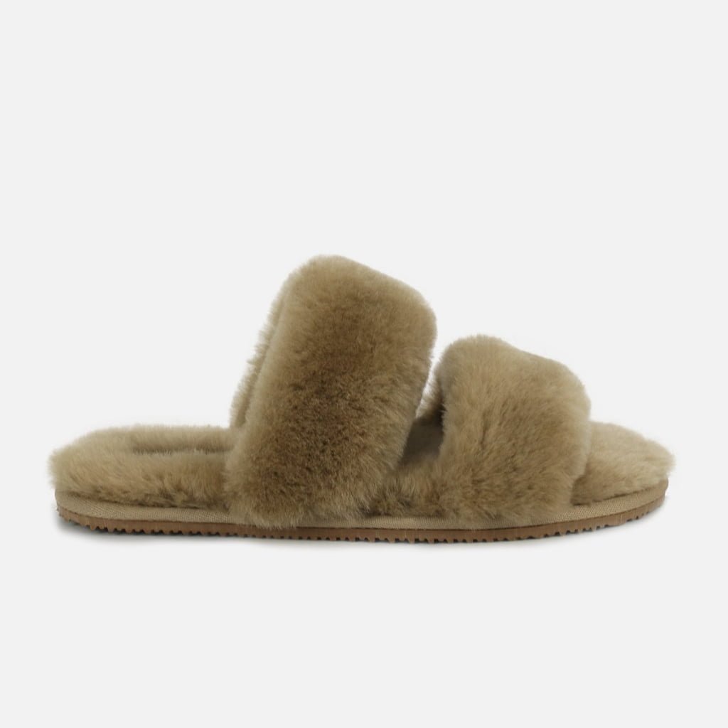 A personalized two-strap slipper in warm light beige, constructed with fluffy sheepskin and tailored for individual fit.