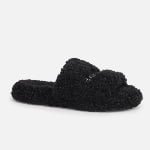 A single black slide slipper made of soft faux shearling fur fabric, featuring a custom minimalist design