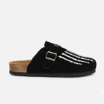 Custom black cow suede mules featuring white skeleton embroidery, cork footbed, personalized fit for unique everyday wear.