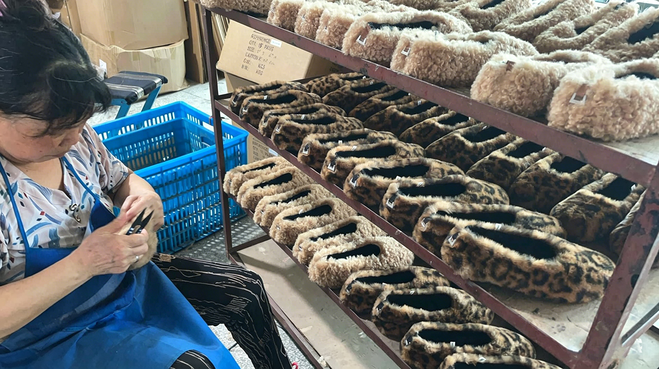 factory-worker-inspecting-fluffy-leopard-print-slippers